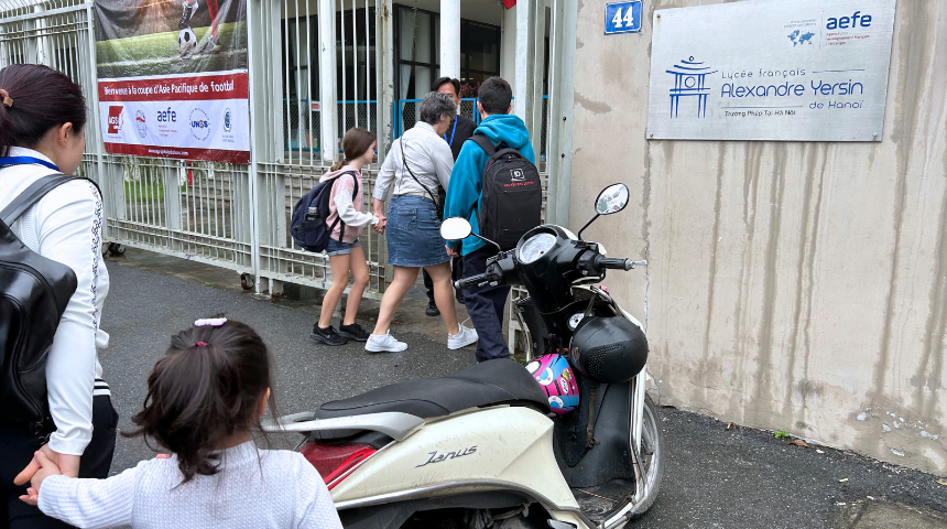 Photographie de parents accompagnant leurs enfants au lycée français Alexandre Yersin d'Hanoï (Vietnam)